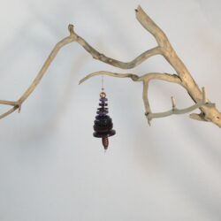 Branche sèche sur laquelle est accroché un sapin formé par des boutons bleus empilés du plus grand en bas au plus petit en haut et surmonté d'une perle. De petites perles sont intercalées entre les boutons pour leur donner un peu de hauteur et un côté dansant. Une perles en bois suggère le tronc. Une ficelle dorée permet de le suspendre.