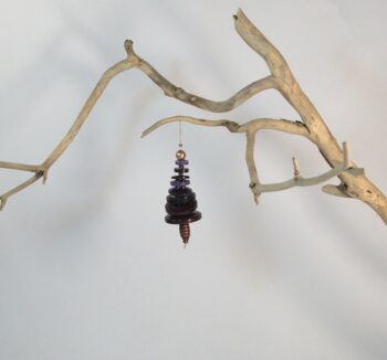 Branche sèche sur laquelle est accroché un sapin formé par des boutons bleus empilés du plus grand en bas au plus petit en haut et surmonté d'une perle. De petites perles sont intercalées entre les boutons pour leur donner un peu de hauteur et un côté dansant. Une perles en bois suggère le tronc. Une ficelle dorée permet de le suspendre.