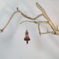 Branche sèche sur laquelle est accroché un sapin formé par des boutons rouges empilés du plus grand en bas au plus petit en haut et surmonté d'une perle. De petites perles sont intercalées entre les boutons pour leur donner un peu de hauteur et un côté dansant. Une perles en bois suggère le tronc. Une ficelle dorée permet de le suspendre.