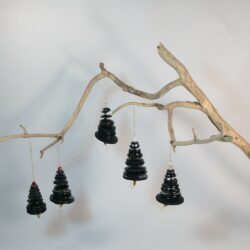 Branche sèche sur laquelle sont suspendus des sapins formés par des boutons noirs empilés du plus grand en bas au plus petit en haut et surmonté d'une perle. De petites perles sont intercalées entre les boutons pour leur donner un peu de hauteur et un côté dansant. Des perles en bois suggèrent les troncs. Une ficelle dorée permet de les suspendre.